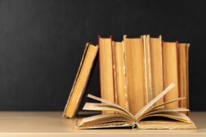 Old books on a table, with one book open