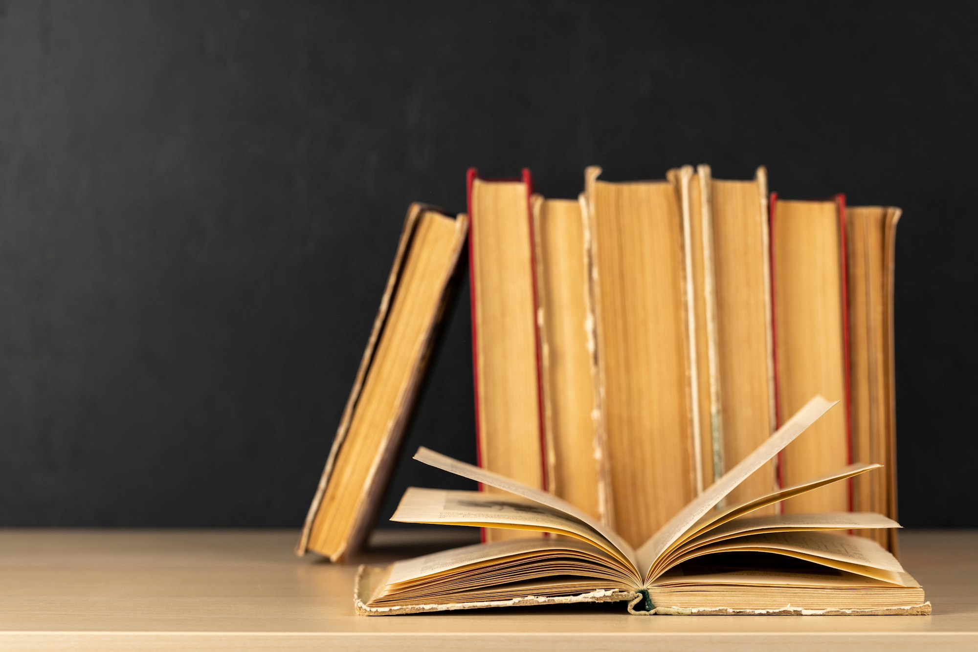 Old books on a table, with one book open